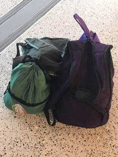 Photo of two small backpacks and a shoe bag. 
